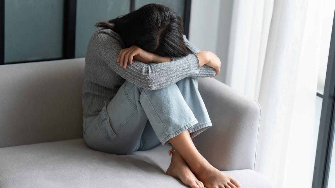 Woman carrying multiple responsibilities while appearing overwhelmed, representing overfunctioning and emotional exhaustion