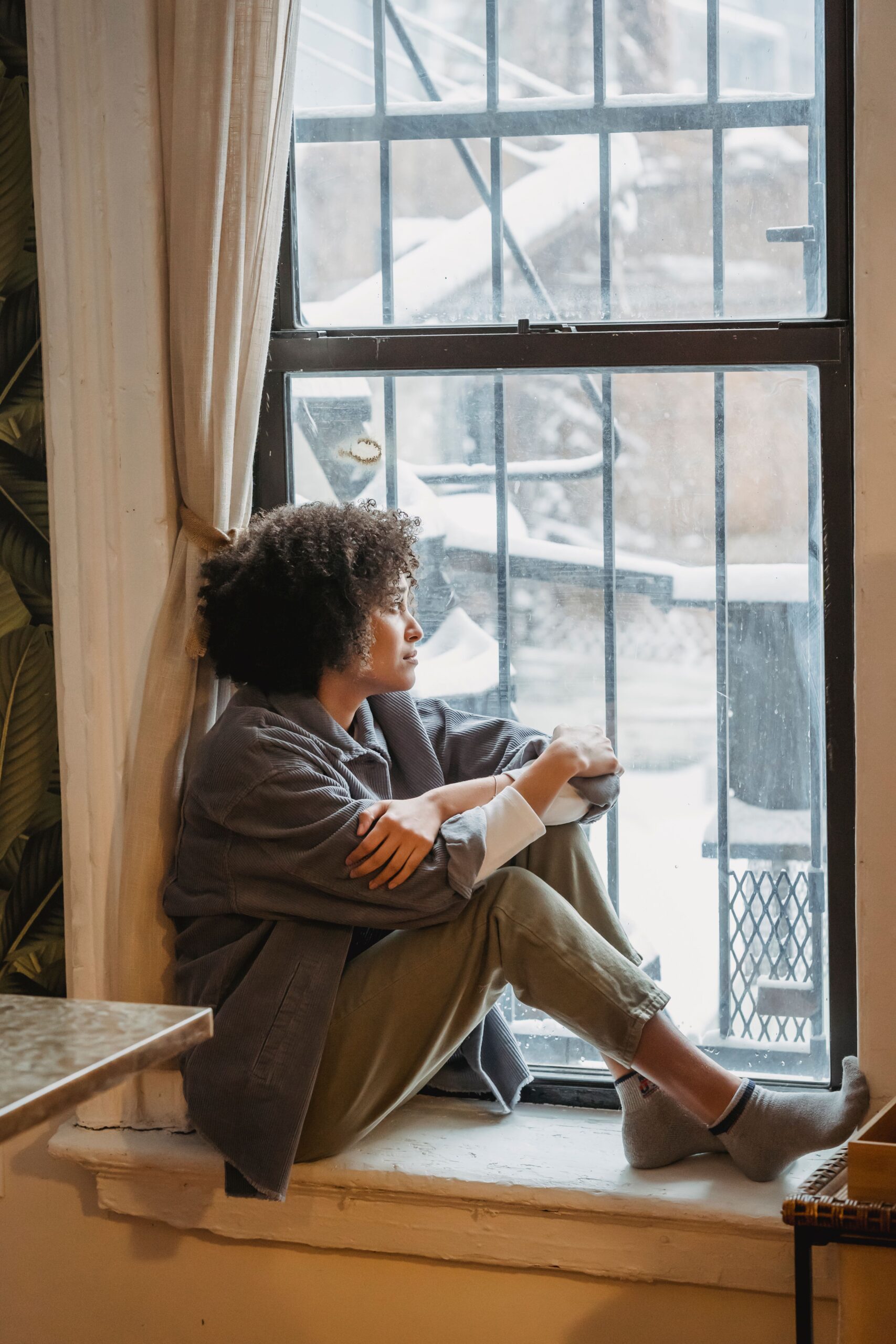 Woman sitting alone reflecting, representing the exhaustion of carrying everyone else's emotional burdens in codependent friendships